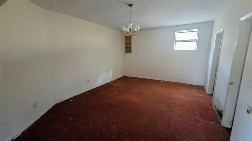 An open living space features classic wall finishes and a hanging light fixture.