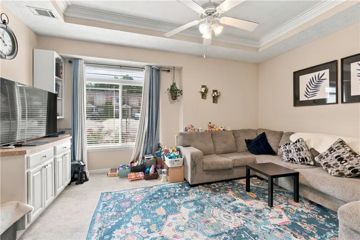 An inviting tray ceiling and crown molding add classical detail to this comfortable living area.