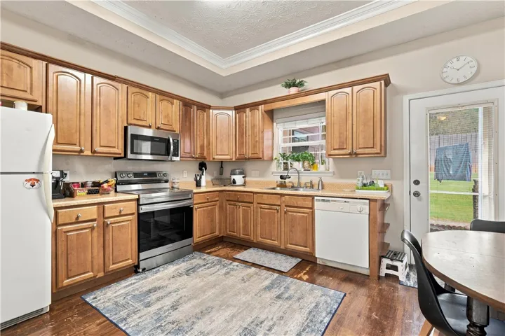 Rich wood cabinetry and classic crown molding frame this functional kitchen workspace with backyard access.
