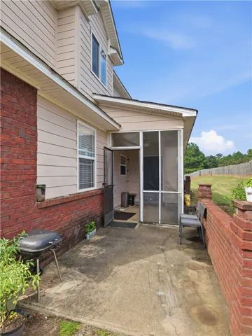 A concrete back patio adjoins a screened porch framed by classic brick and siding details.