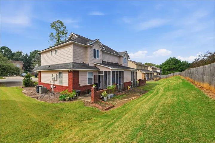 An expansive green lawn borders this multi-level home featuring brick accents and a screened porch.