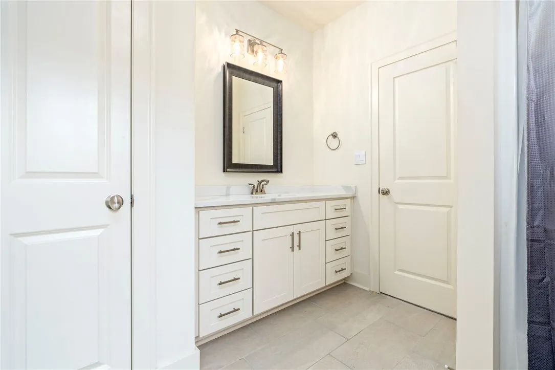 A single vanity with stone countertops highlights this functional bathroom.