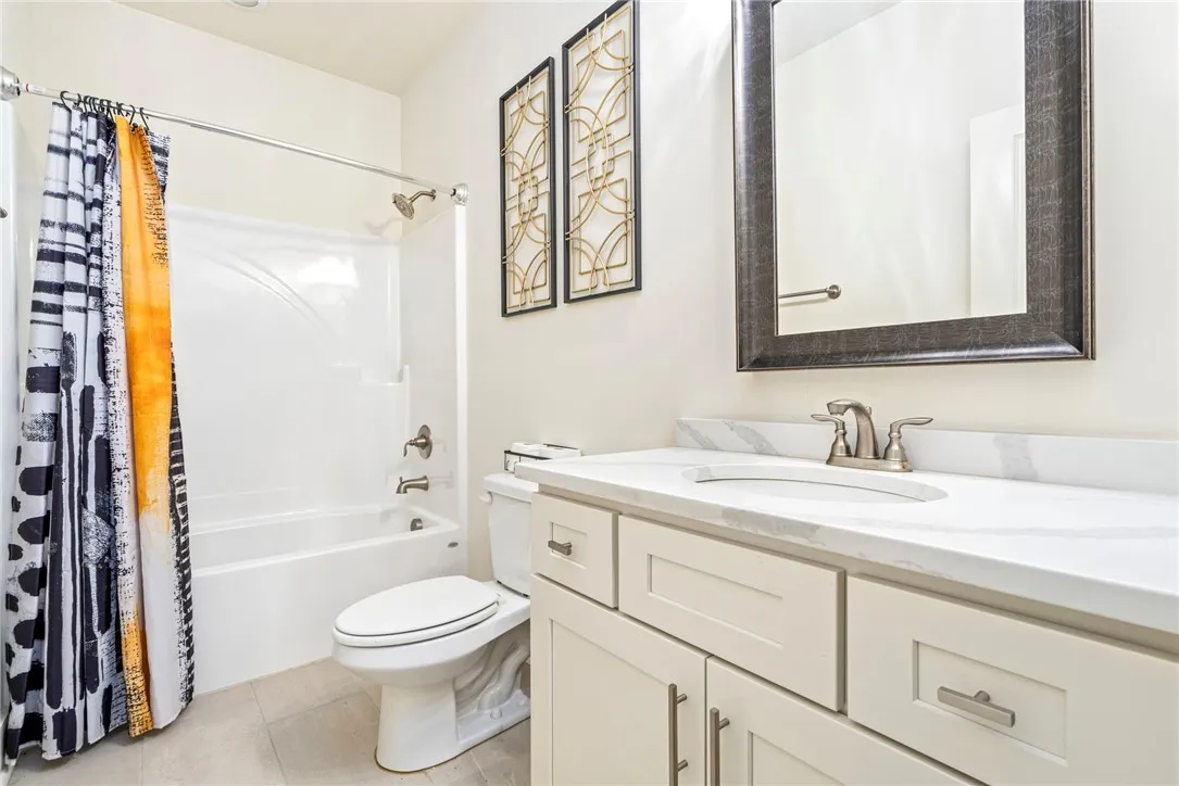 An elegant stone counter highlights the classic vanity in this neat secondary bath.