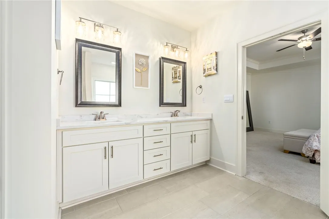 A spacious double vanity with stone countertops highlights this master bathroom design.