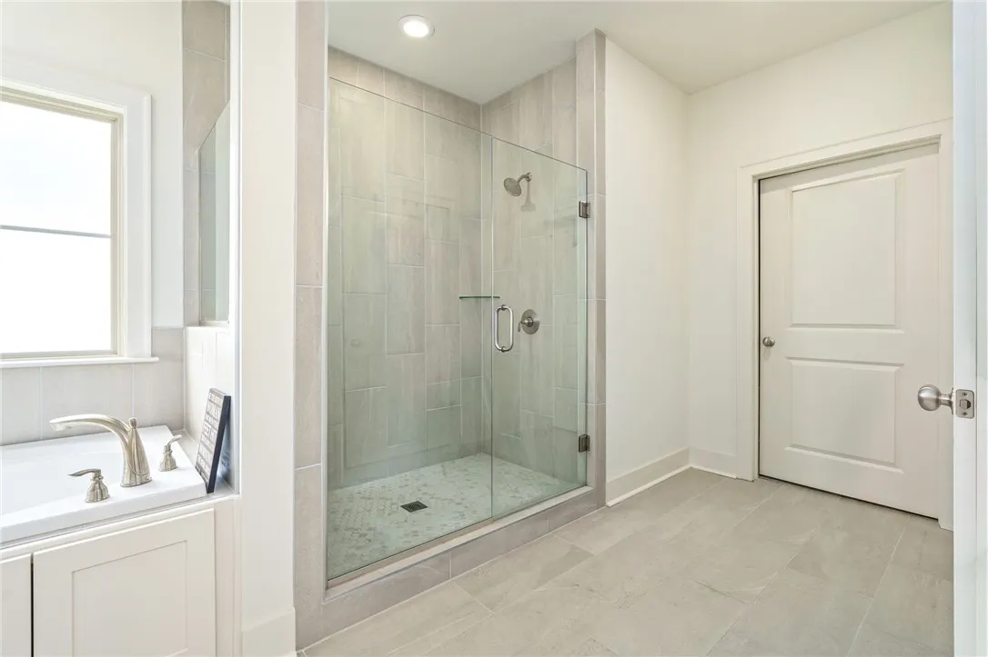 Clean lines and tiled finishes define this modern bathroom with a glass-enclosed walk-in shower.