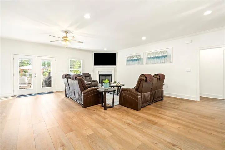 Rich wood flooring and a corner fireplace highlight this inviting living area with outdoor access.