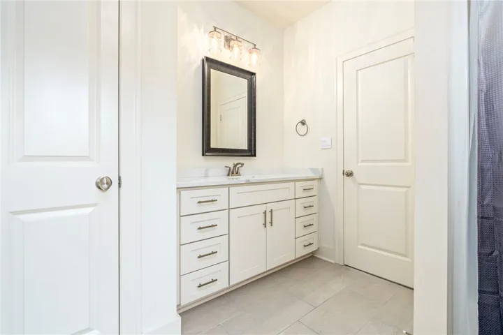 A single vanity with stone countertops highlights this functional bathroom.