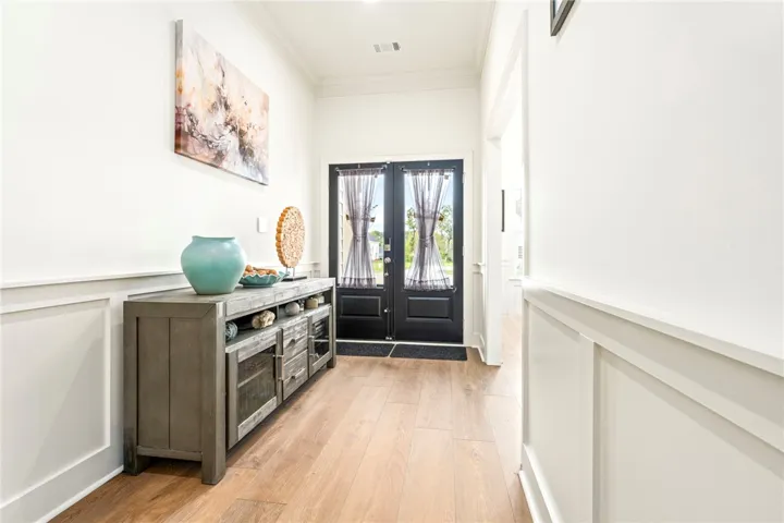 Elegant wainscoting and warm wood-look floors welcome guests inside this inviting entrance foyer.