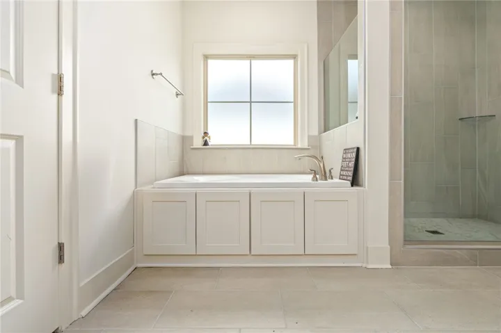 Tiled flooring and a built-in soaking tub create a tranquil atmosphere in this bathroom.