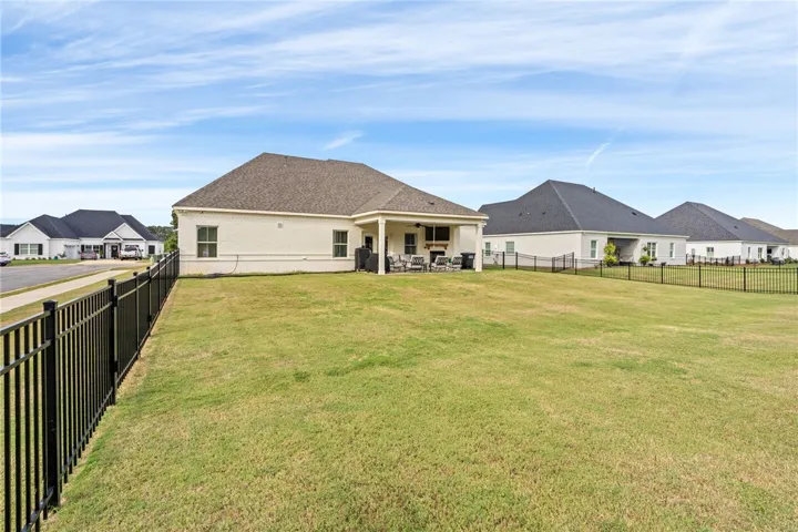 A spacious, fully fenced lawn lines the back of this modern brick residence.