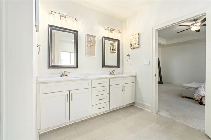 A spacious double vanity with stone countertops highlights this master bathroom design.