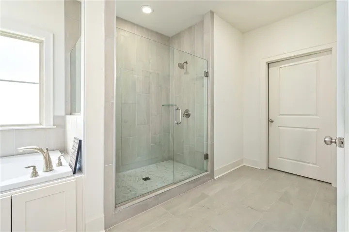 Clean lines and tiled finishes define this modern bathroom with a glass-enclosed walk-in shower.