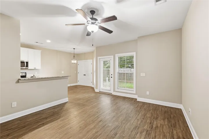 Rich wood-look flooring and crisp neutral walls anchor this open living area.