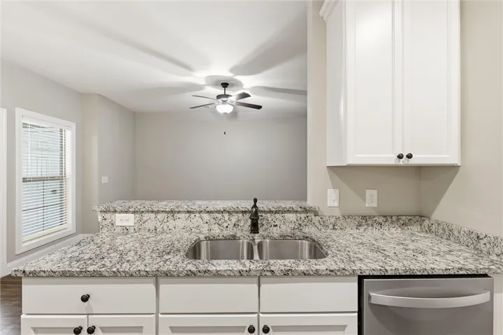 Granite countertops and crisp white cabinetry define this highly functional breakfast bar area.