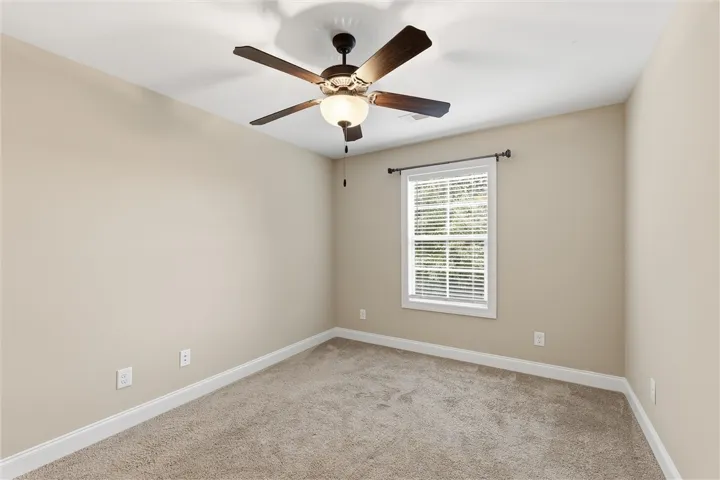 Soft carpeting pairs with neutral walls in this versatile secondary bedroom space.