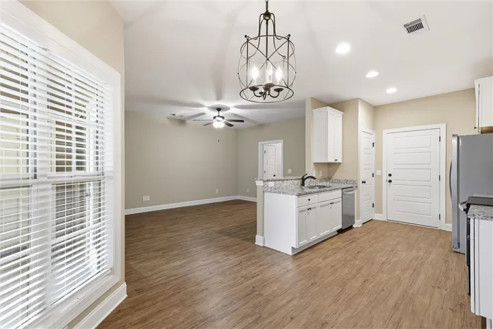 Gleaming wood-look floors anchor a versatile open-concept layout connecting the kitchen and living areas.
