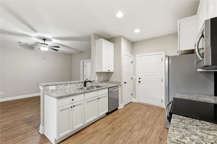 An open floor plan connects the kitchen with granite countertops to the adjacent living space.