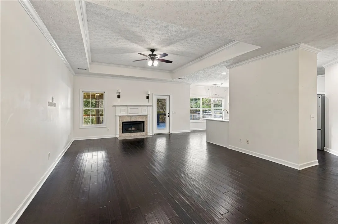 Rich dark wood floors anchor an airy, open layout complete with a classic focal fireplace.