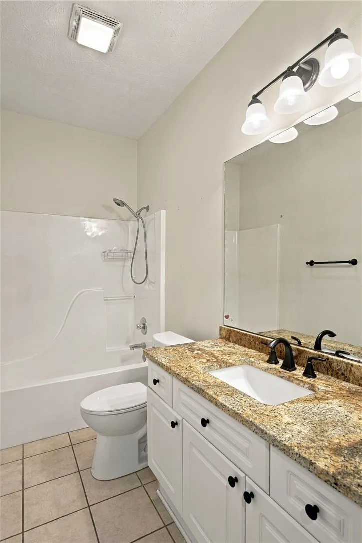Polished stone counters elevate this classic bathroom layout with timeless appeal.