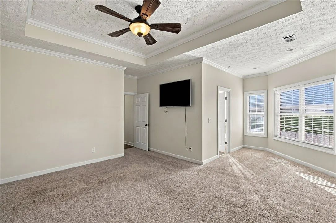 Plush carpeting and tray ceilings elevate this comfortable bedroom suite.