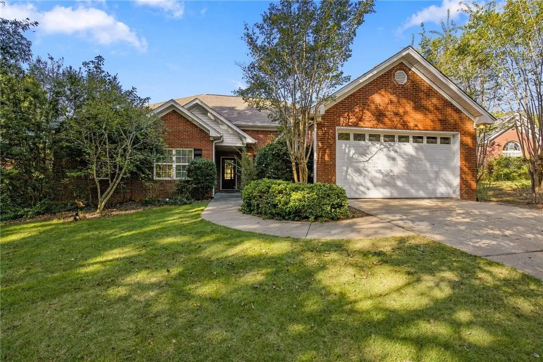 A classic brick exterior and concrete driveway define this charming single-story residence.