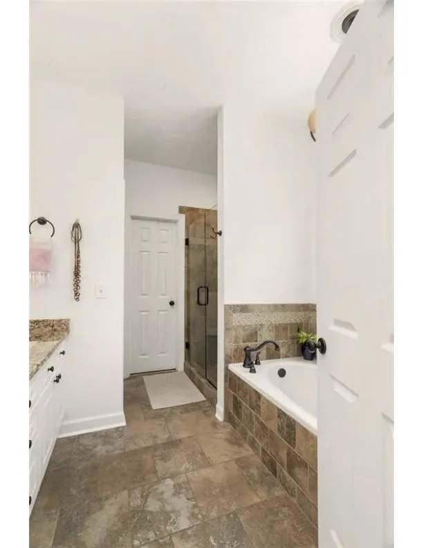 A classic soaking tub and tile finishes anchor this well-appointed private bath.