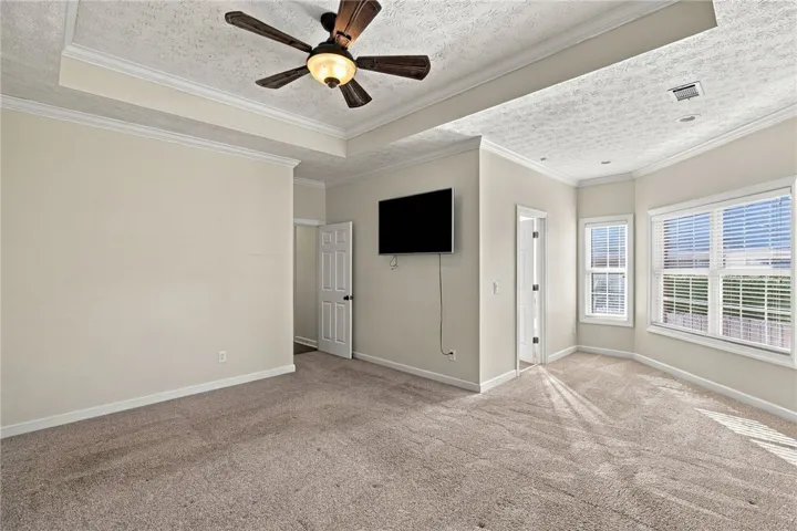 Plush carpeting and tray ceilings elevate this comfortable bedroom suite.