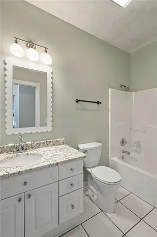 A well-appointed vanity with stone countertops highlights this functional bathroom space.