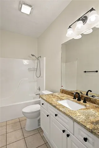 Polished stone counters elevate this classic bathroom layout with timeless appeal.