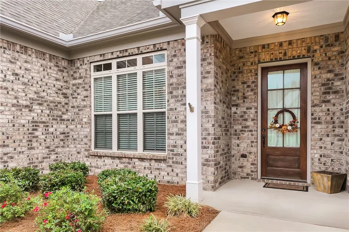 A classic brick exterior accents the welcoming covered front porch and handsome wood entry door.