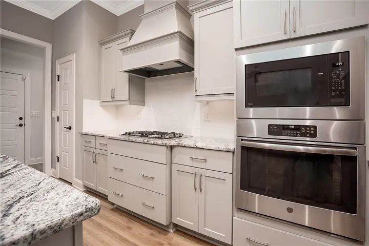 Modern cabinetry and stone countertops frame the built-in stainless steel appliances.