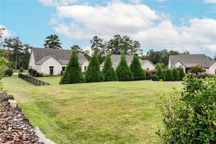 A manicured green lawn transitions smoothly to classic brick structures under a bright sky.