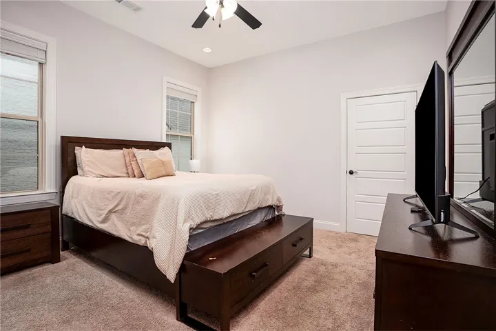 High ceilings and soft carpeting create a serene atmosphere in this inviting bedroom space.