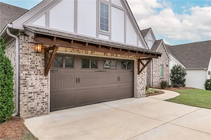 Timeless brick accents and Tudor-inspired trim complement the handsome carriage-style garage facade.