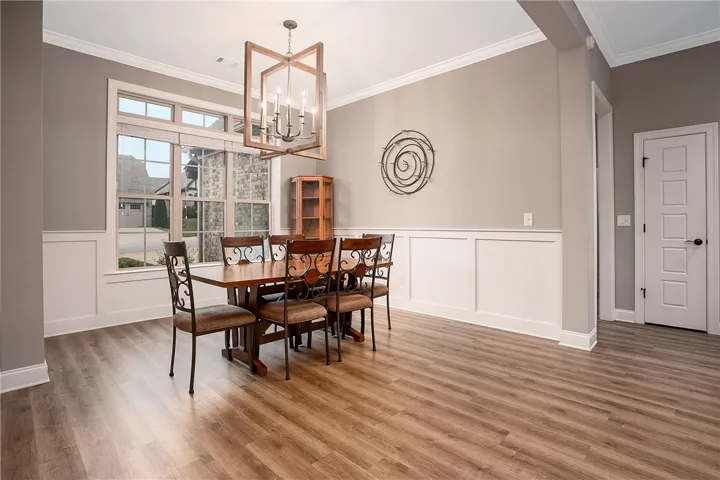 Elegant wainscoting and warm wood-look floors define this inviting dining space.