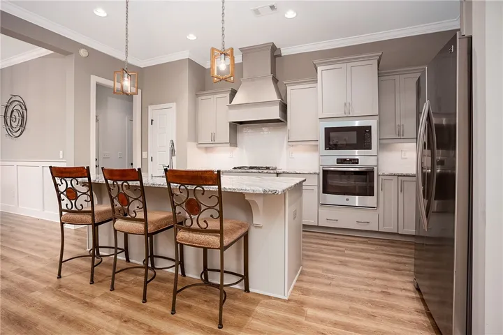 Polished stone counters, custom cabinetry, and recessed lighting define this modern kitchen layout.
