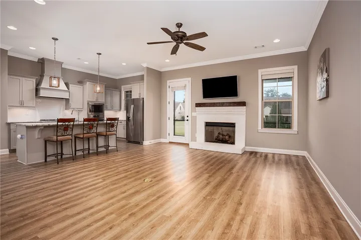 An open floorplan connects the comfortable living space to a modern kitchen with hardwood flooring.