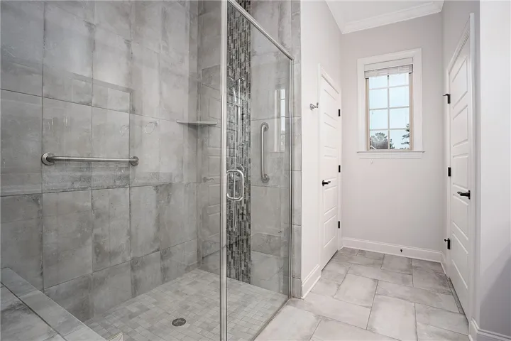 Fine tilework and a seamless glass enclosure define this modern walk-in shower.