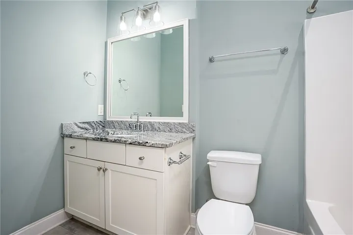Polished granite countertops bring a clean finish to this well-appointed washroom.
