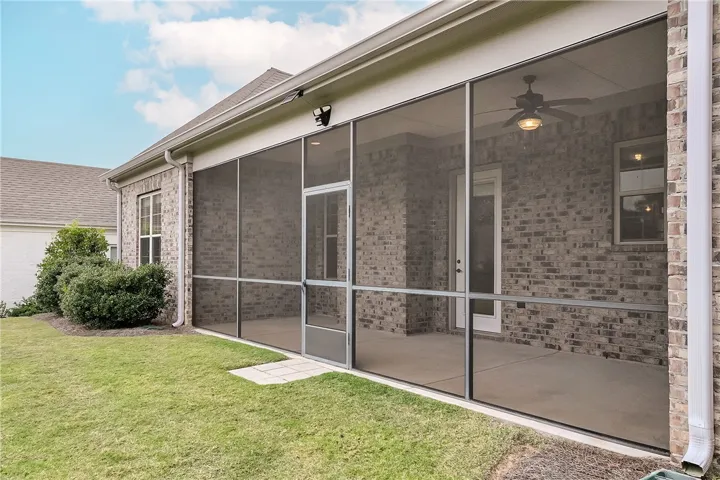 A classic brick exterior transitions seamlessly to a sheltered outdoor living space with a manicured lawn.