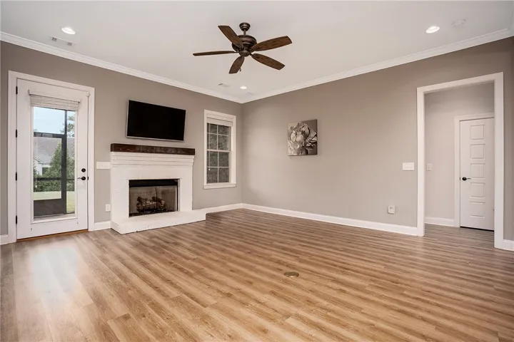 Polished wood floors and a classic brick fireplace anchor this welcoming, open living space.