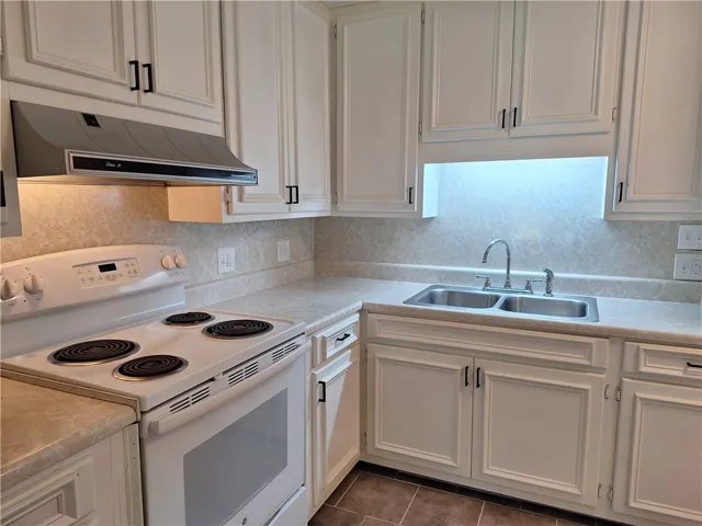 Abundant cabinetry and durable countertops define this classic cooking space with tiled floors.