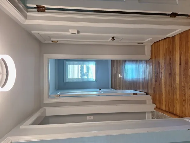 Gleaming hardwood floors run throughout the hallway and adjacent rooms of this classic layout.