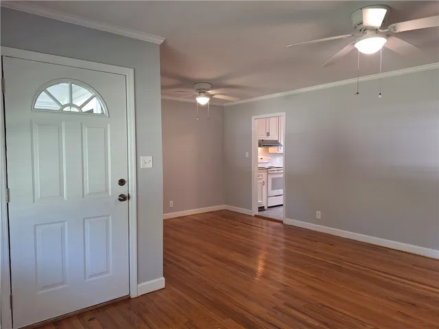 Gleaming hardwood floors and classic crown molding frame this versatile open living space.