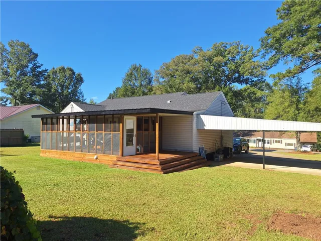 An inviting screened porch and attached carport extend the functional living space of this home.