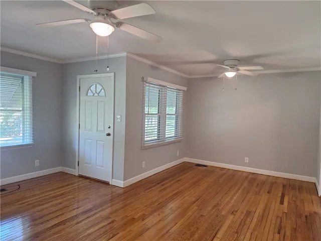 Gleaming hardwood floors run throughout this versatile living area featuring detailed crown molding.