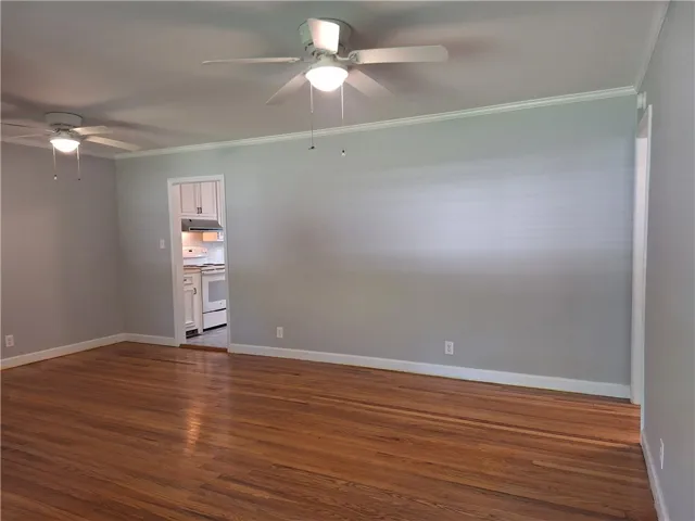 Rich hardwood flooring and classic crown molding anchor this open living space.