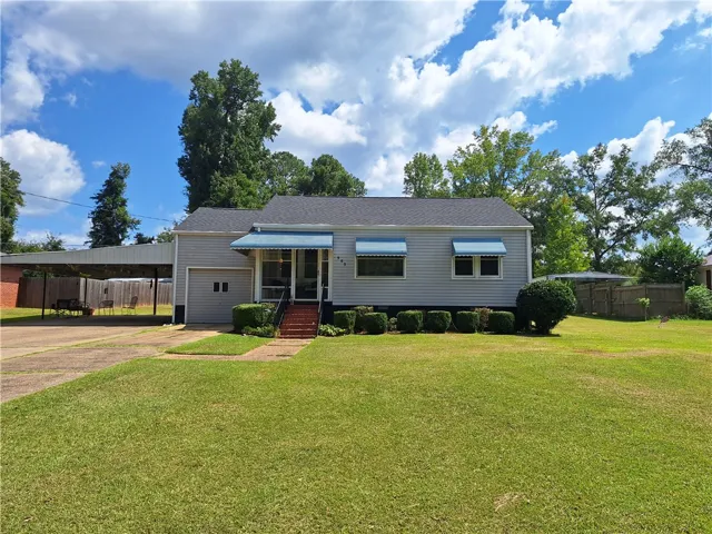 Classic siding exterior and clean architectural lines define this single-story home set on a grassy lawn.