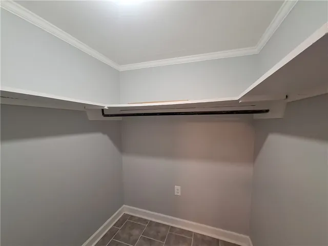 Crown molding and durable tile flooring elevate this functional walk-in closet space.