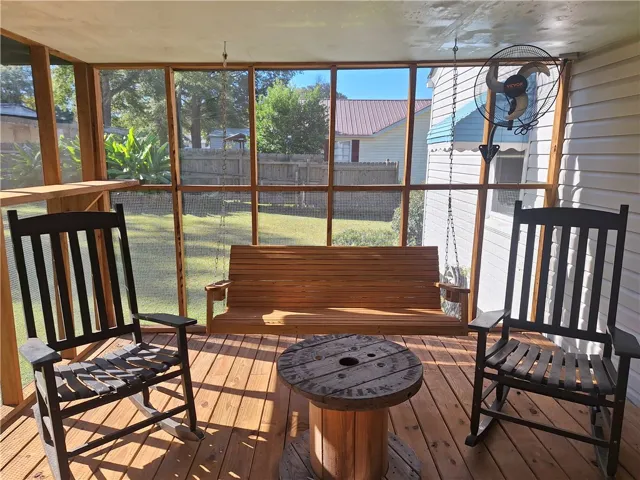A screened porch overlooks the back yard, offering wood decking and framed views.